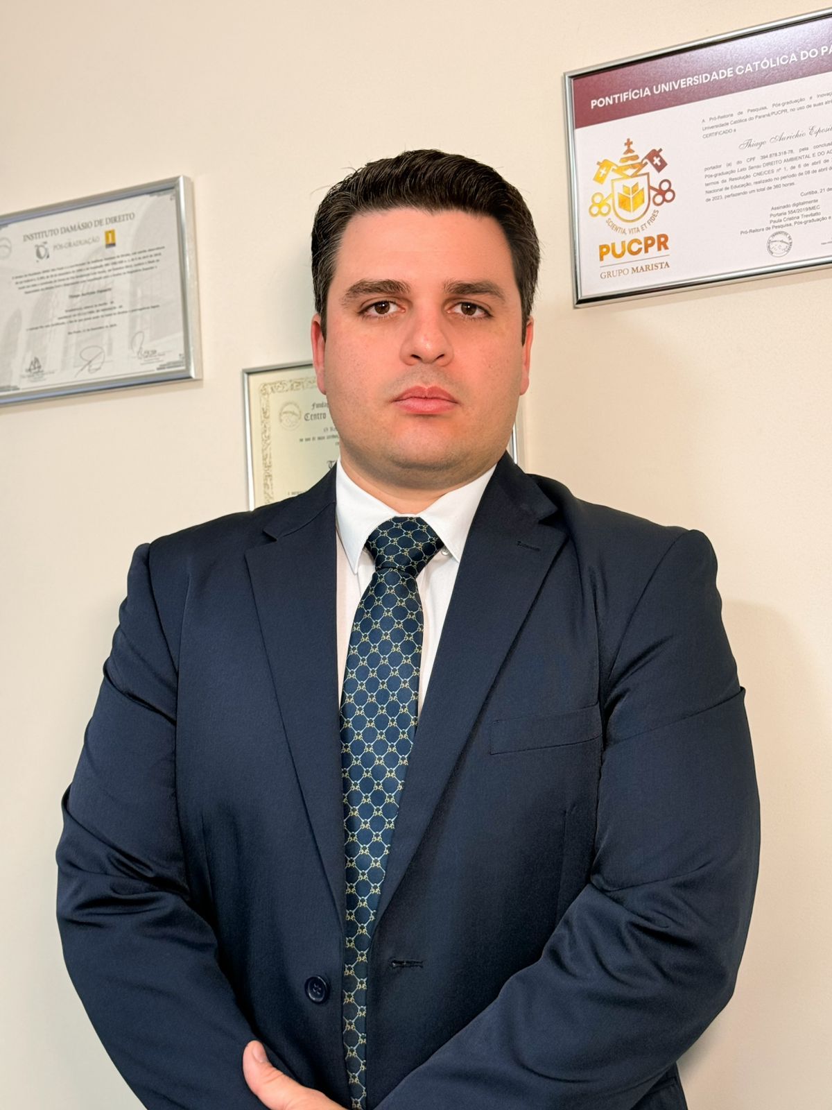 Dr. Thiago Esposito em seu escritório, com certificados de pós-graduação em Direito Ambiental e do Agronegócio ao fundo